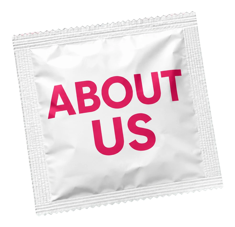 A Kissy Bang Bang 6x6cm white foil condom wrapper, custom printed with the words About Us in raspberry pink.